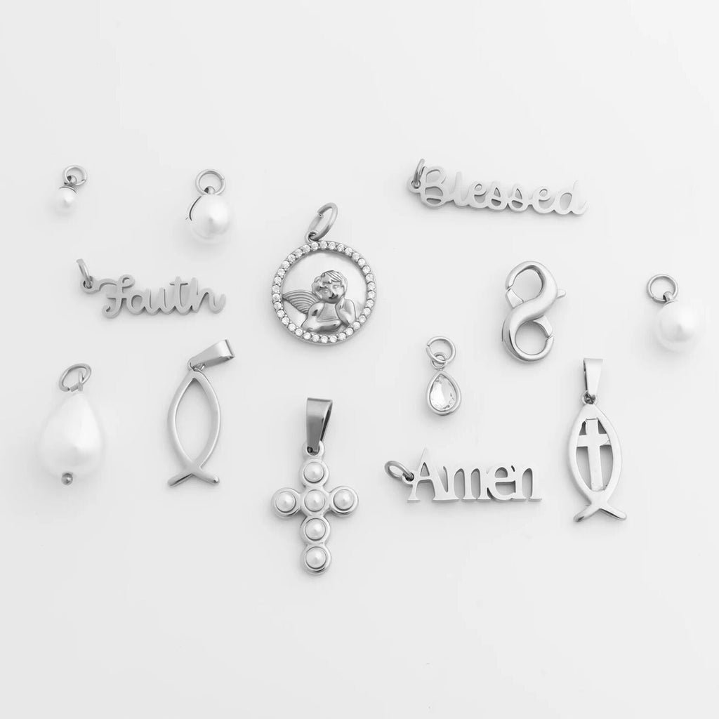 Collection of various silver faith based pendants on a light gray background