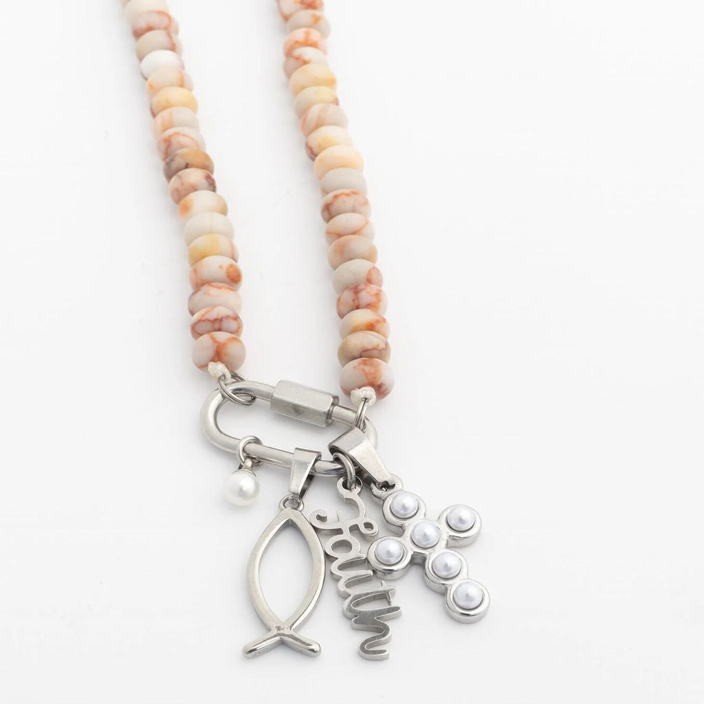 Necklace with beaded chain and silver charms on a white background