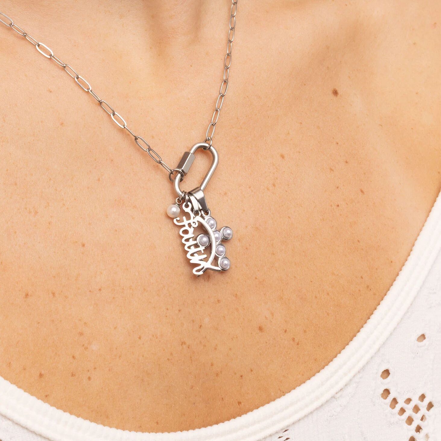 Silver necklace with a leaf-shaped pendant on a person's neck