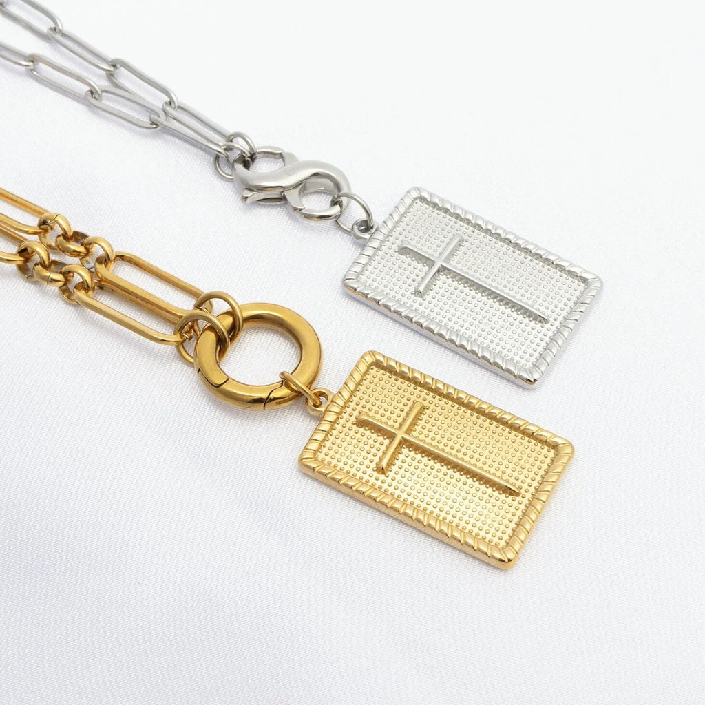 Two gold and silver necklaces with cross pendants on a white background