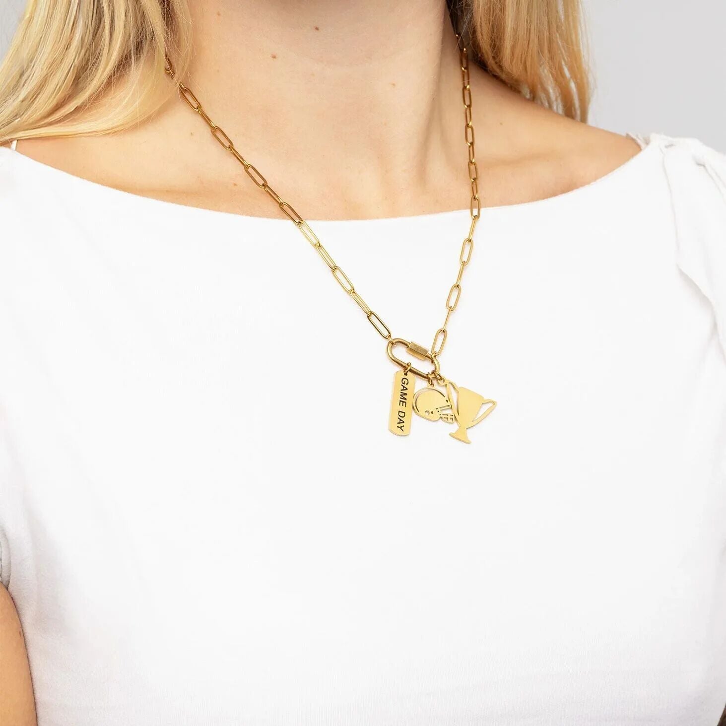 Gold necklace with heart and key pendant on a white background