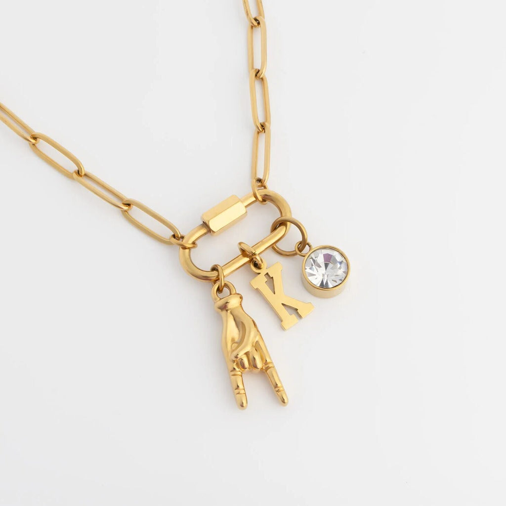 Gold necklace with charms on a white background