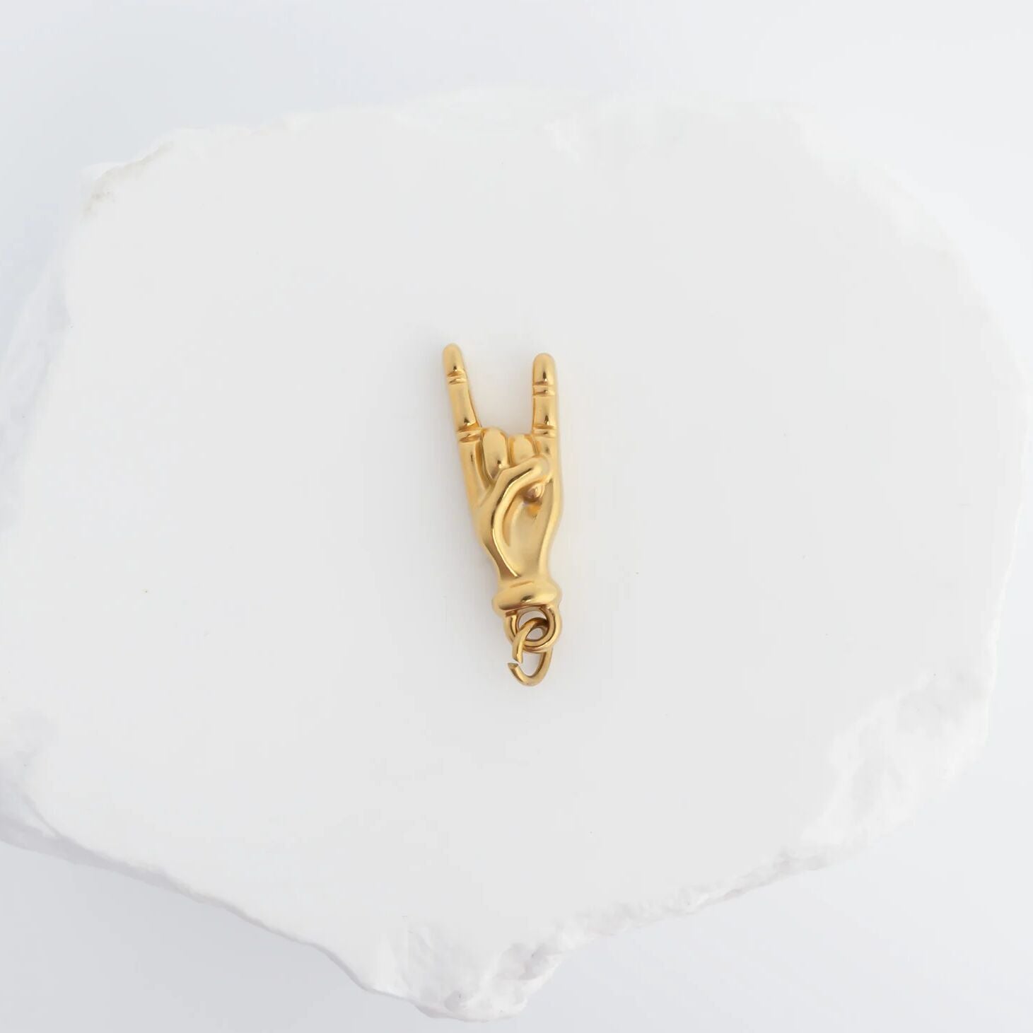 Gold equestrian-themed pendant on a white background