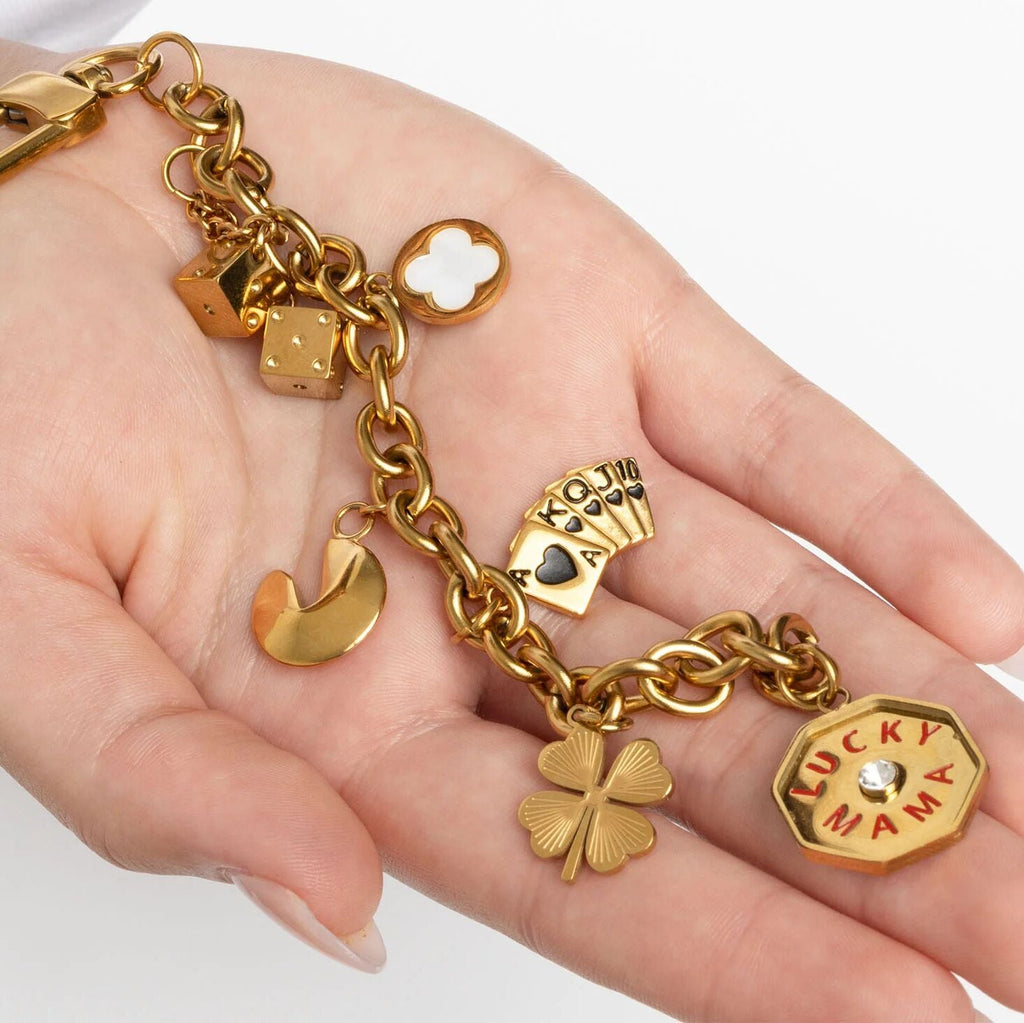 Gold Dice Charm  with various charms held in a hand on a white background