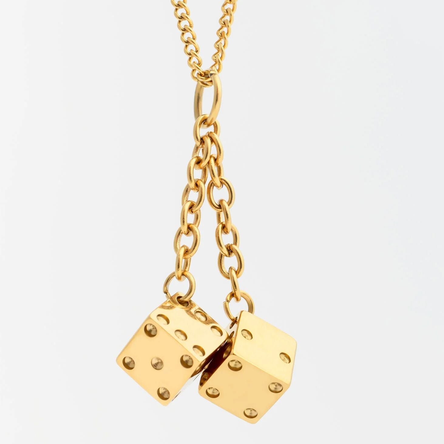 Gold Dice Charm on a light gray background