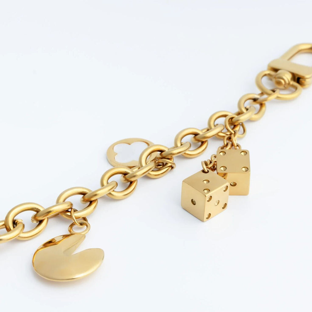 Gold keychain with fortune cookie, lucky charms and dice charm on a white background