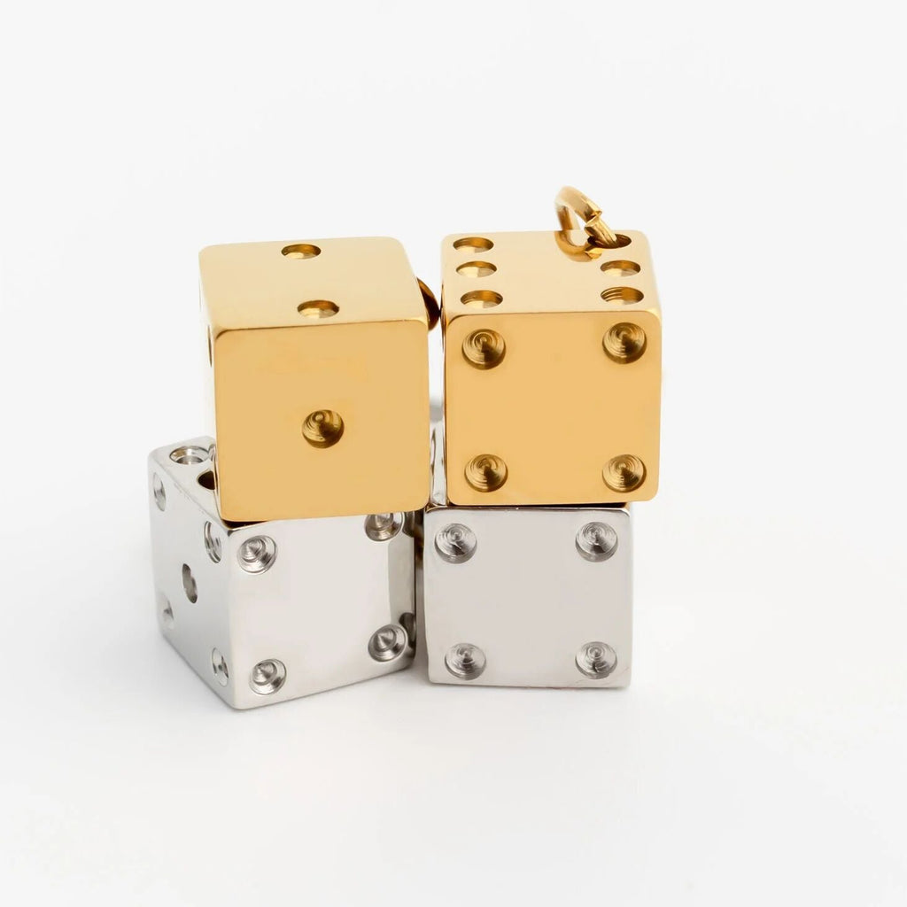Gold and silver dice-shaped pendants on a white background