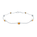 A silver bracelet with small orange gemstones attached to it.
