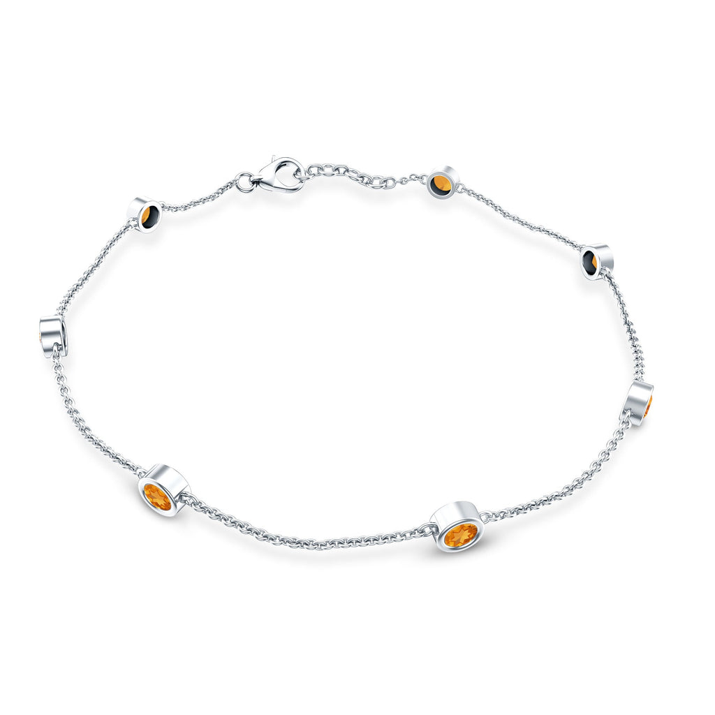 A silver bracelet with small orange gemstones attached to it.