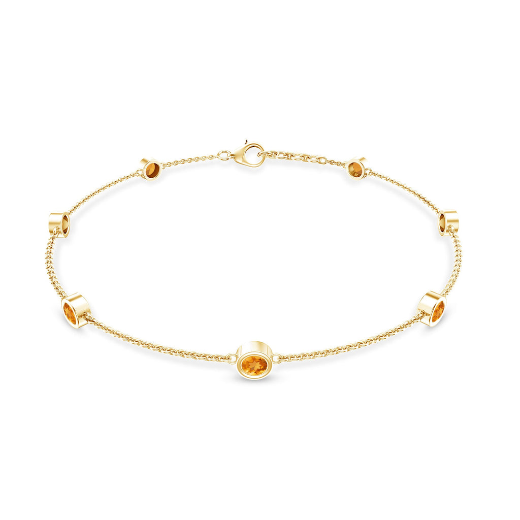 A gold-colored bracelet with small round stones or gemstones attached to it.