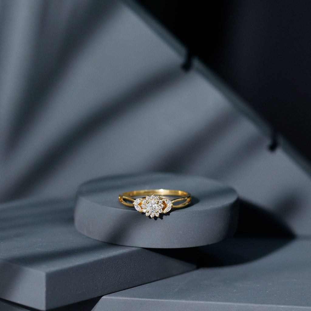 A gold ring with a large diamond in the center is displayed on a gray platform against a dark background.