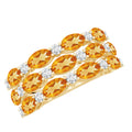 A gold ring with a row of oval-shaped amber-colored gemstones, each adorned with a small round diamond.