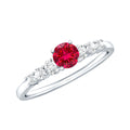 Graduated style lab created ruby and diamond promise ring with a central ruby and side diamonds on a silver band