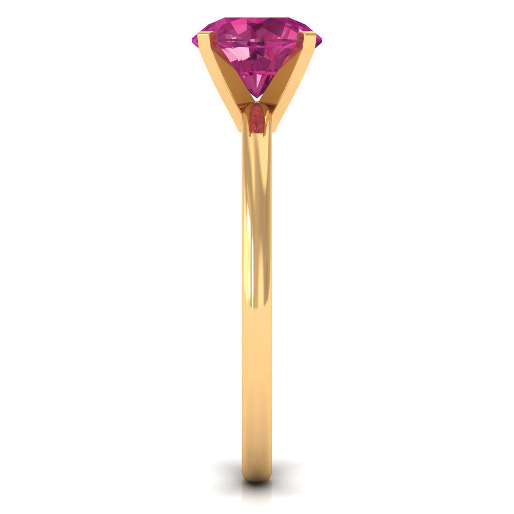 Round pink tourmaline solitaire ring in a gold peg head setting viewed from the side
