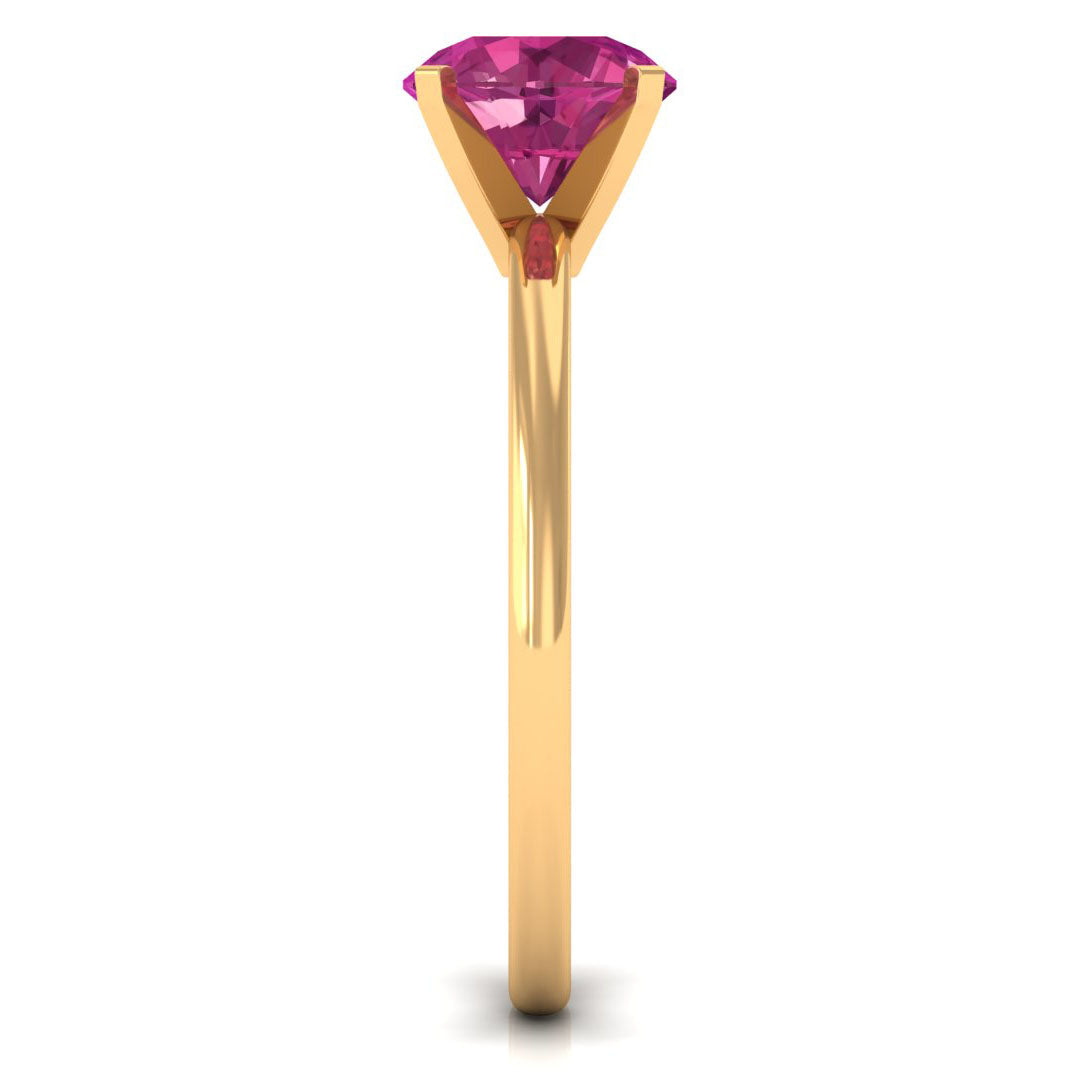 Round pink tourmaline solitaire ring in a gold peg head setting viewed from the side