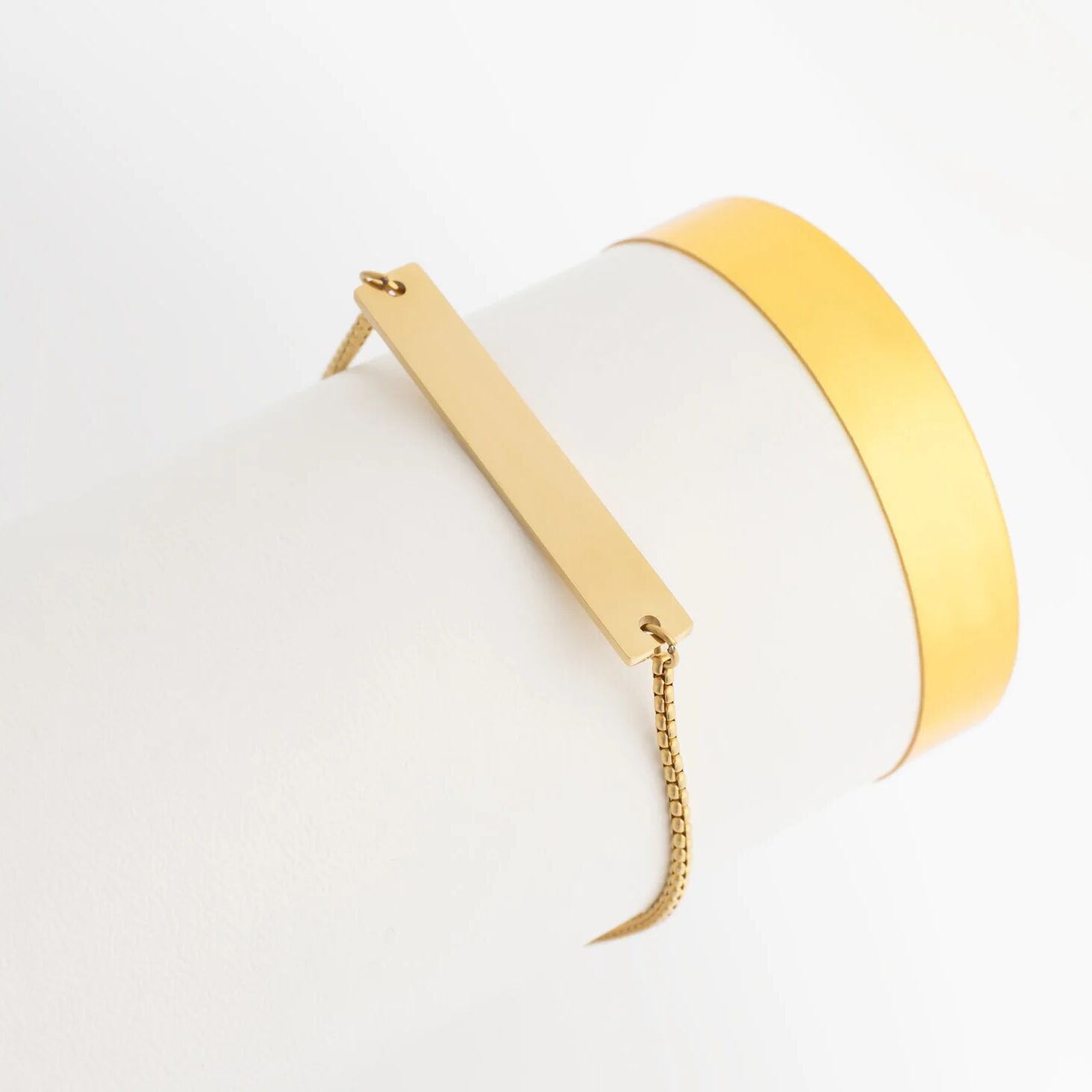 Gold and white earring on a light gray background