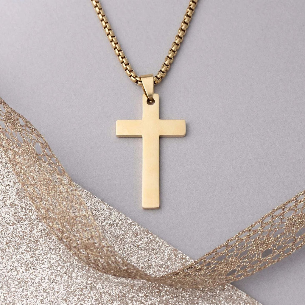 Gold cross necklace on a gray background with gold fabric