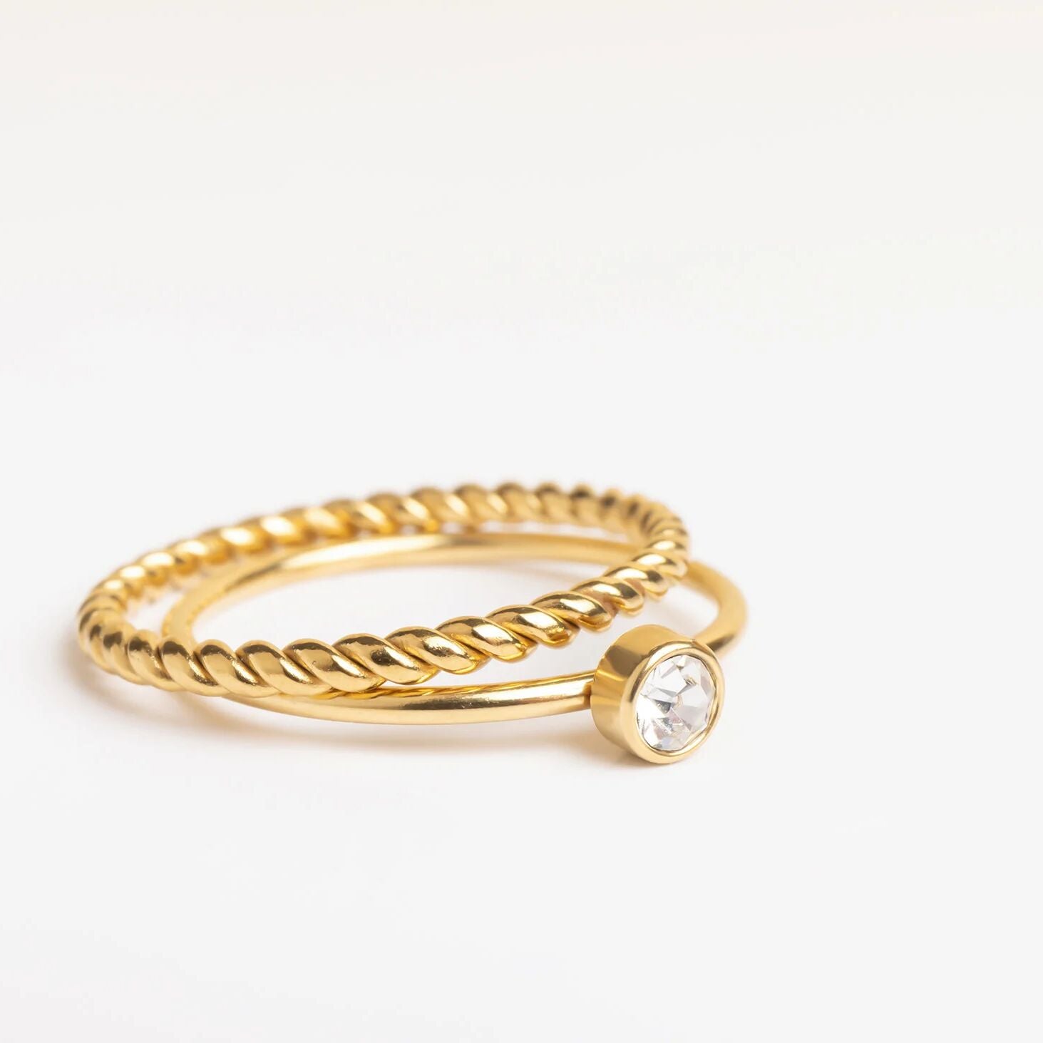 Gold ring with a small diamond on a white background