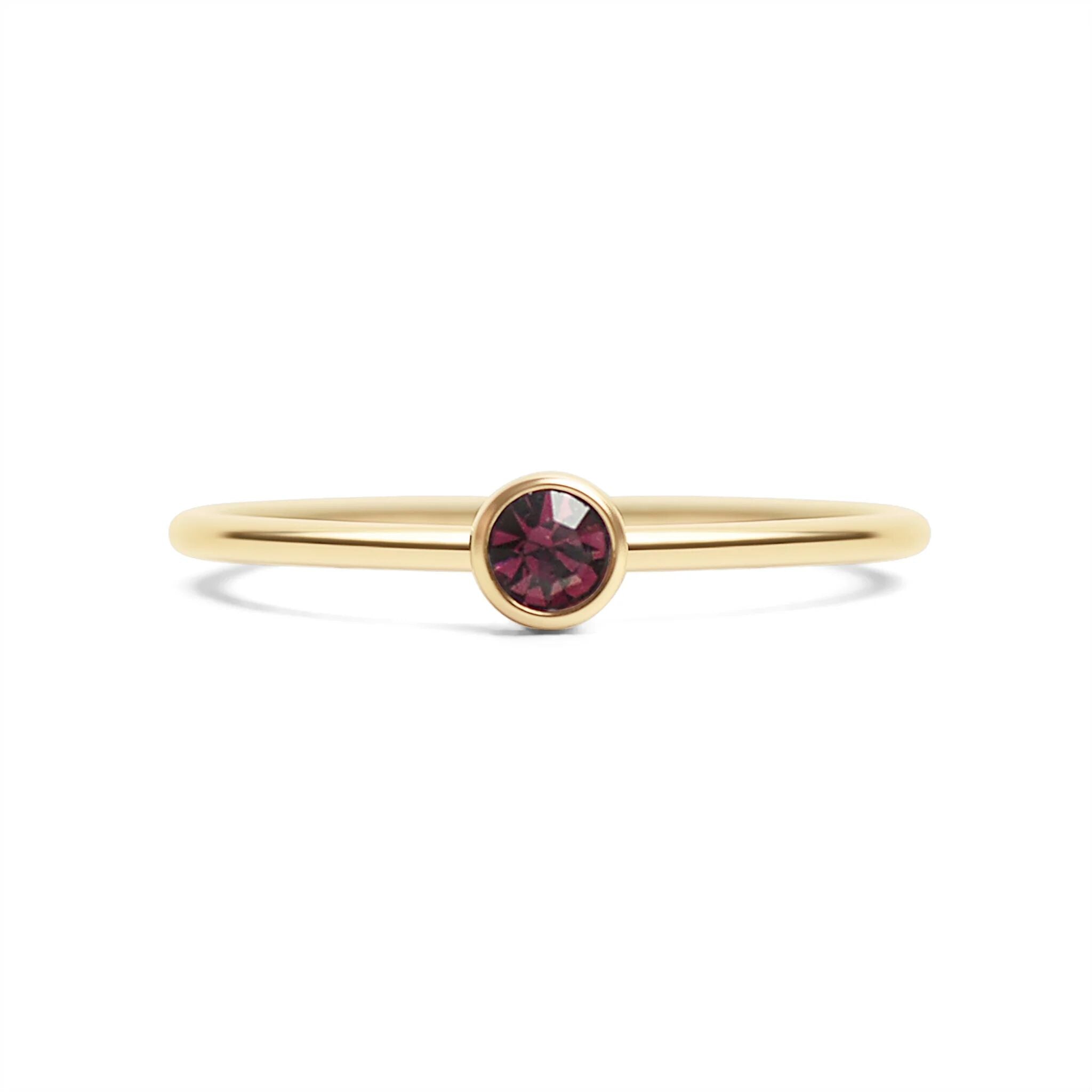 Gold ring with a red gemstone on a white background