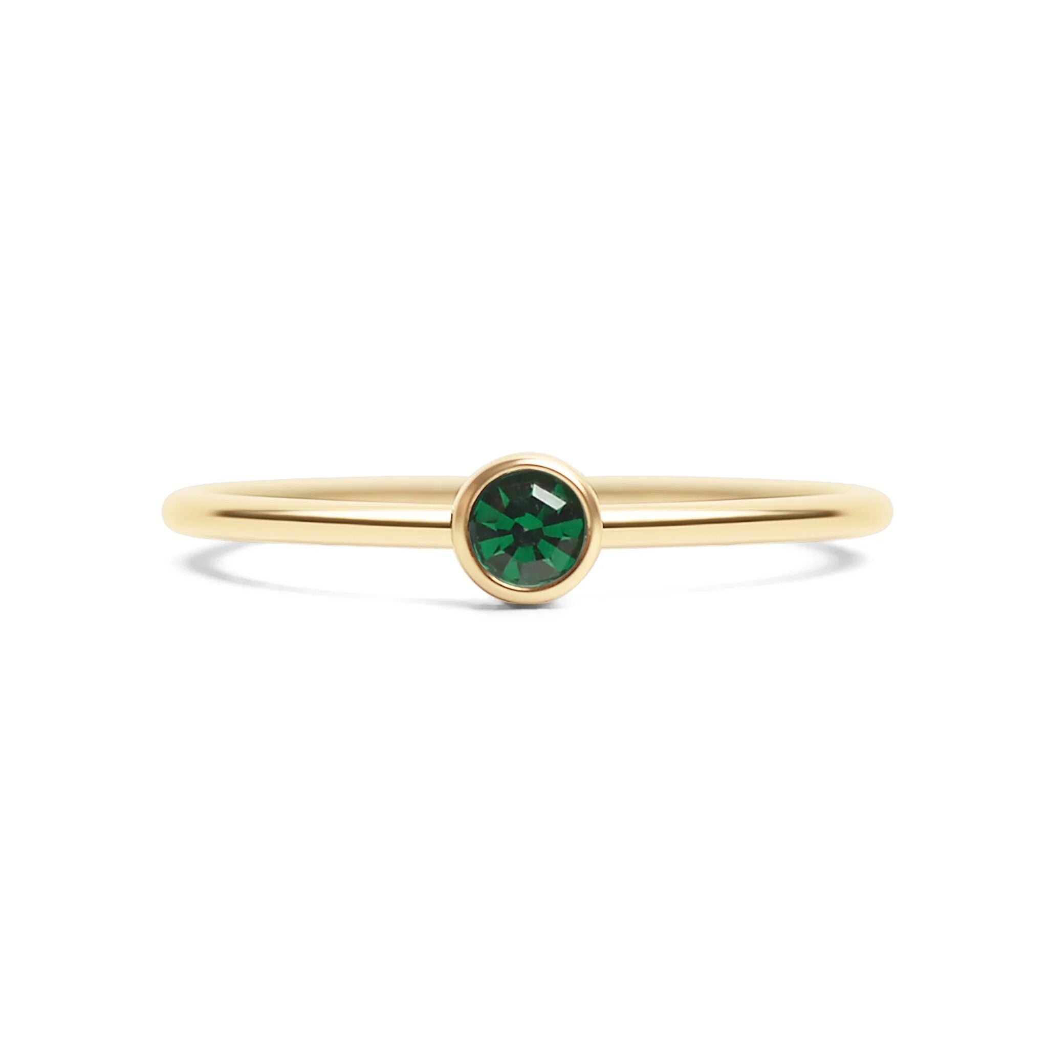 Gold ring with a green gemstone on a white background