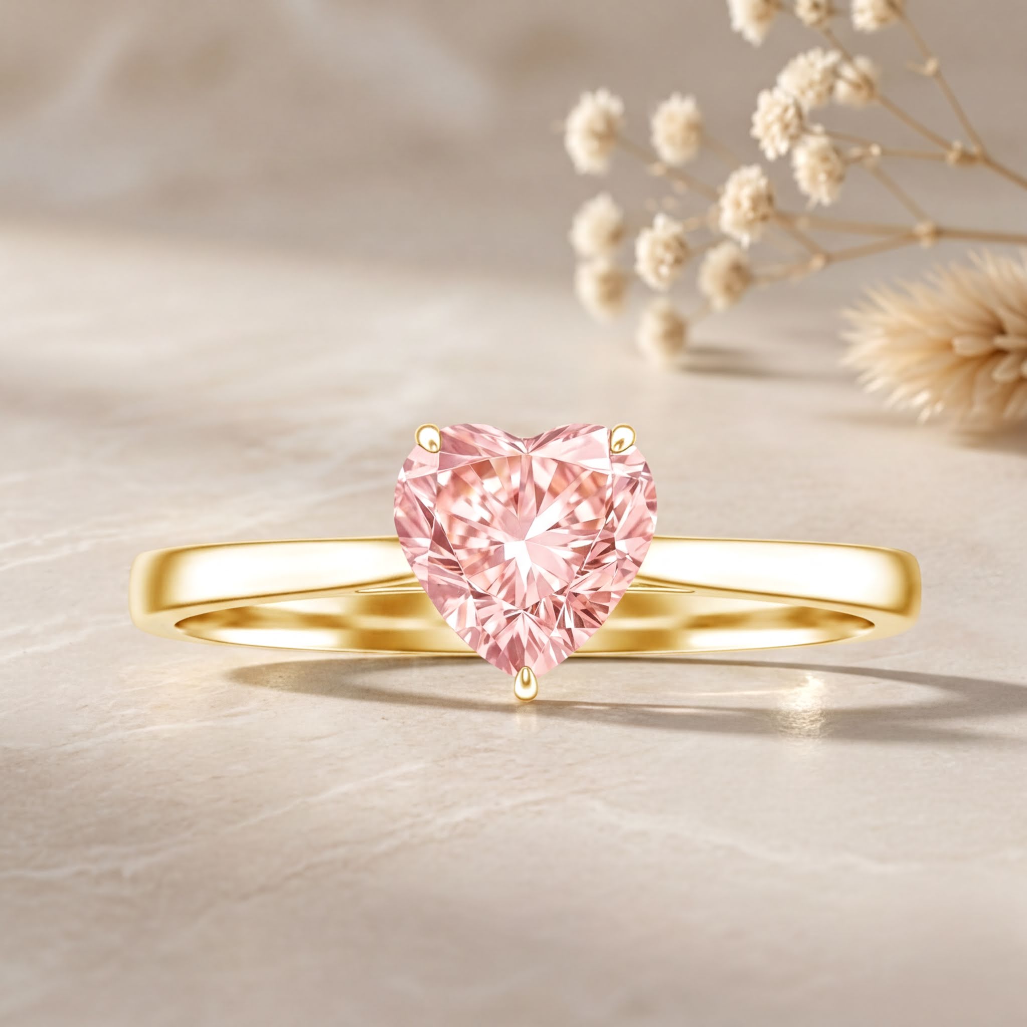A gold ring with a pink diamond in the center, placed on a light-colored surface.