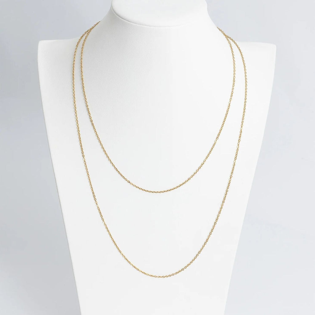 Gold chain necklace on a mannequin with a plain background